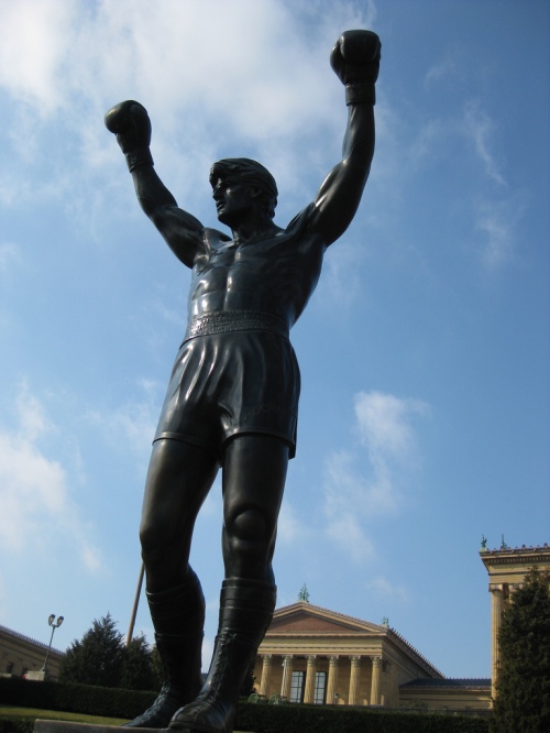 Statue of Rocky in Philadelphia, his arms raised in triumph.